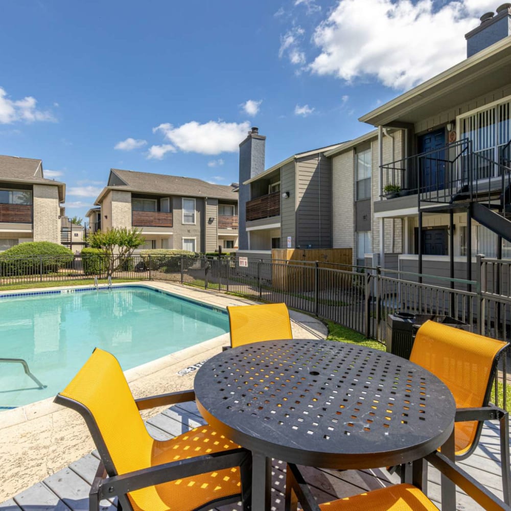 Pool side table and chairs at The Landing at Clear Lake in Webster, Texas