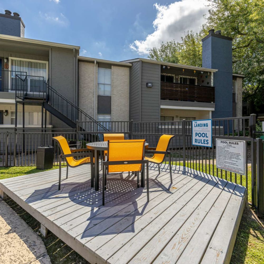 Community gathering area with table and chairs on wood decking at The Landing at Clear Lake in Webster, Texas