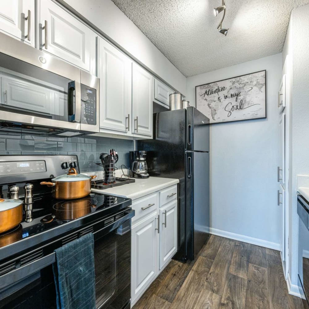 Modern kitchen with wood-style flooring at The Landing at Clear Lake in Webster, Texas