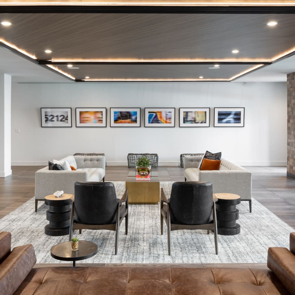 Community lounge area with multiple seating areas and large area rug at Bellrock Sawyer Yards in Houston, Texas