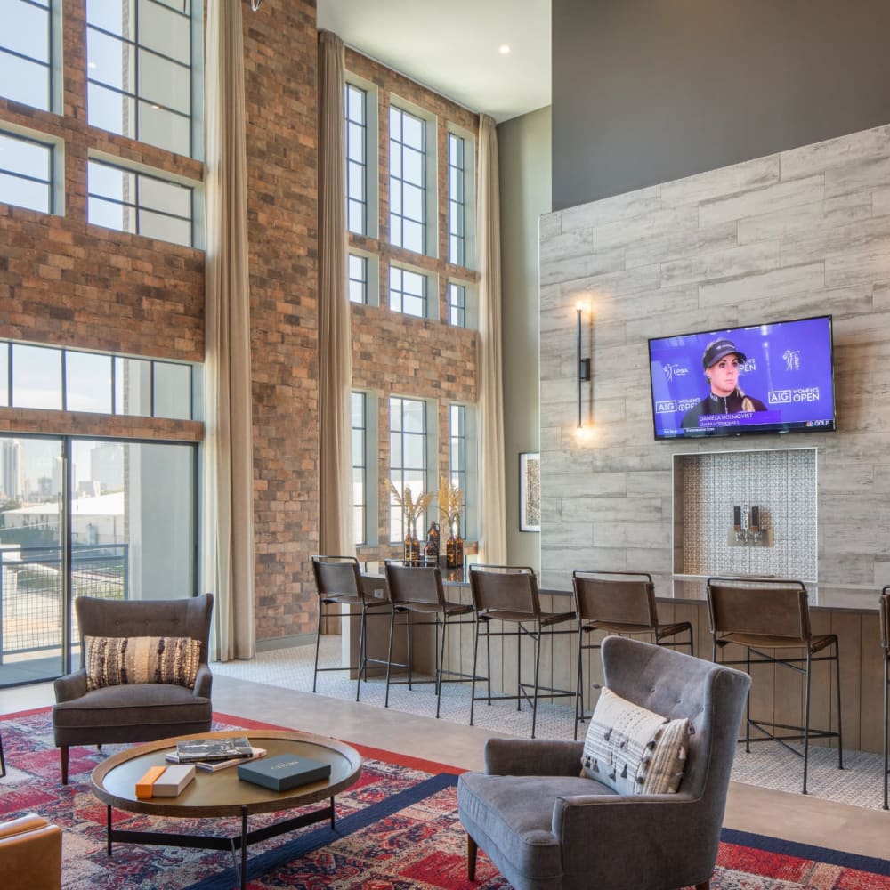 Resident lounge area with seating and large television at Bellrock Sawyer Yards in Houston, Texas