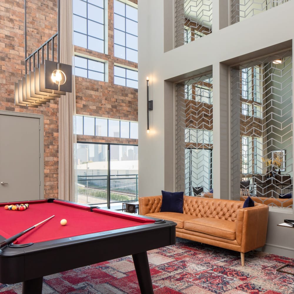 Resident recreational area with modern couch and pool table at Bellrock Sawyer Yards in Houston, Texas