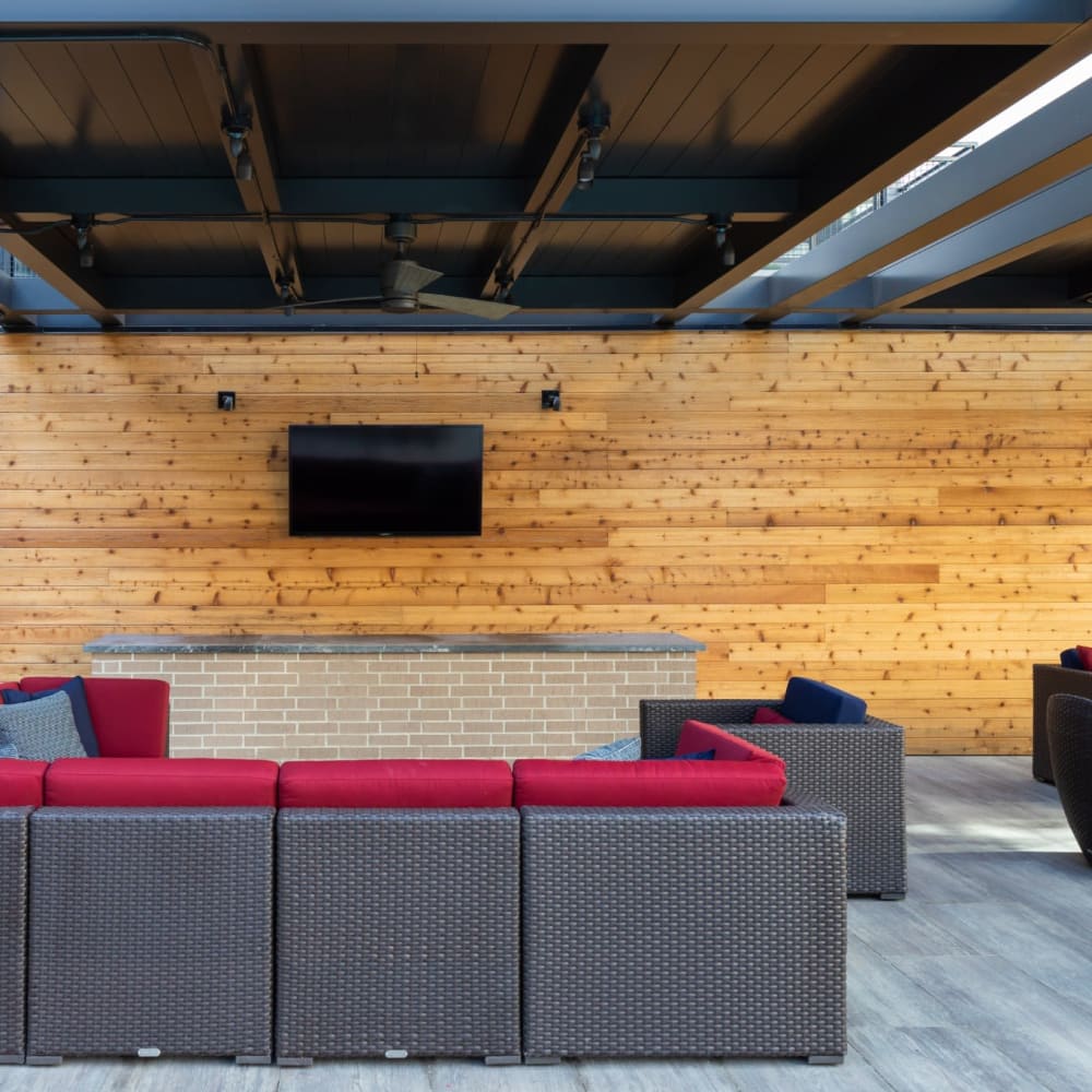 Outdoor resident lounge area with multiple couches and television at Bellrock Sawyer Yards in Houston, Texas