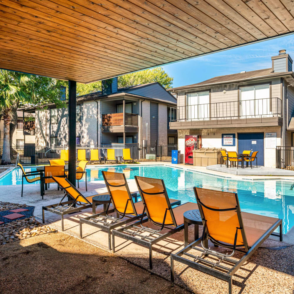 Lounge chairs around barbeque area with a poolside view at The Legacy at Clear Lake in Webster, Texas