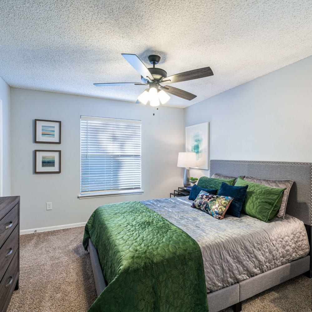 Bedroom with ceiling fan and ample natural light at The Legacy at Clear Lake in Webster, Texas