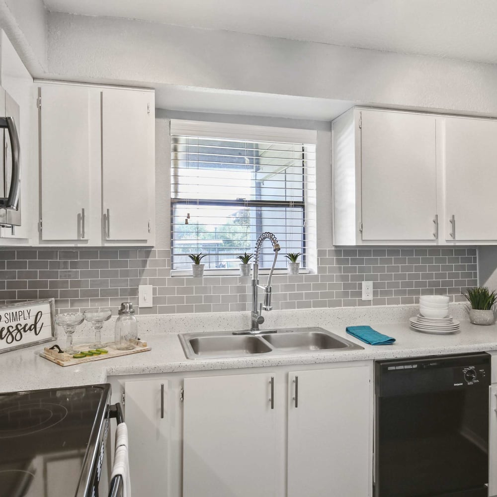 Modern kitchen with black appliances at The Hub at Chisolm Trail in Fort Worth, Texas