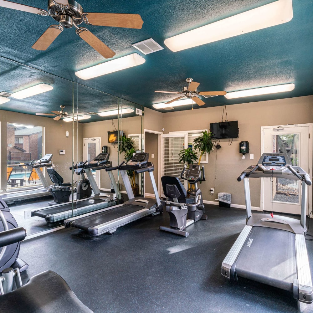 Fitness center with ceiling fans at The Edge at Clear Lake in Webster, Texas