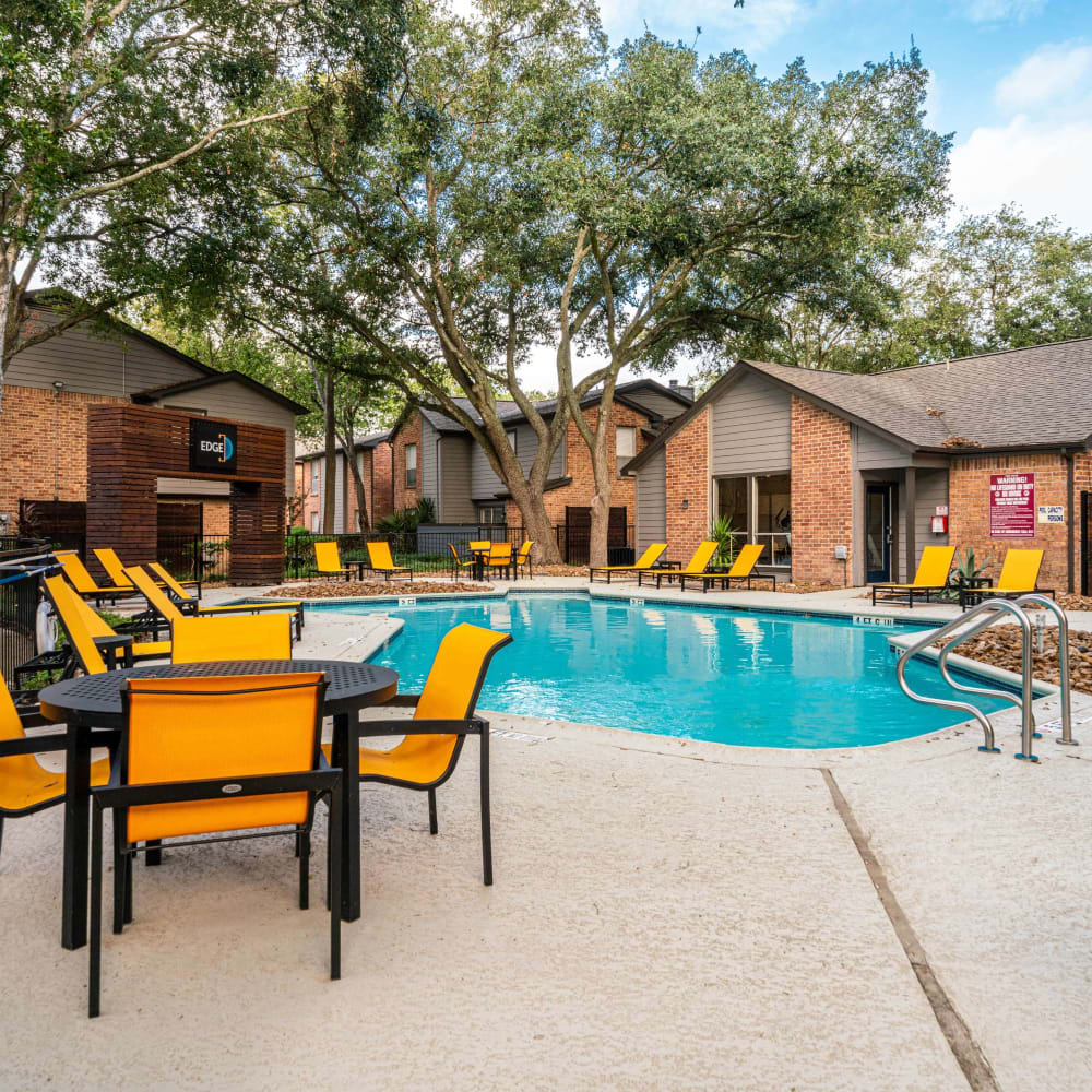 Tables and chair seating around the swimming pool at The Edge at Clear Lake in Webster, Texas