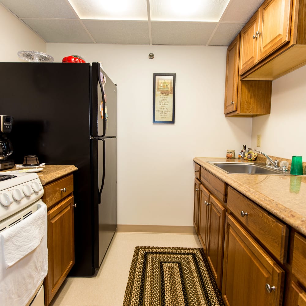 Model kitchen with a black fridge at Connellsville Towers in Connellsville, Pennsylvania