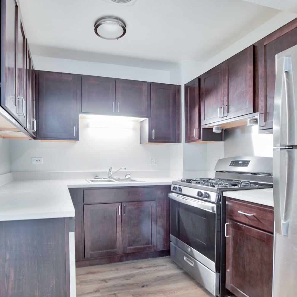Model kitchen with dark wood cabinets at BJ Wright Court Apartments in Chicago, Illinois