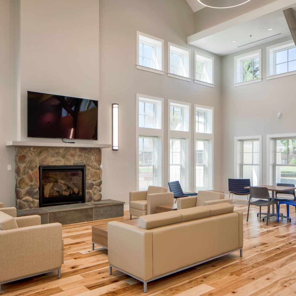 Interior gathering area with fireplace and TV at Squire Village in Manchester, Connecticut