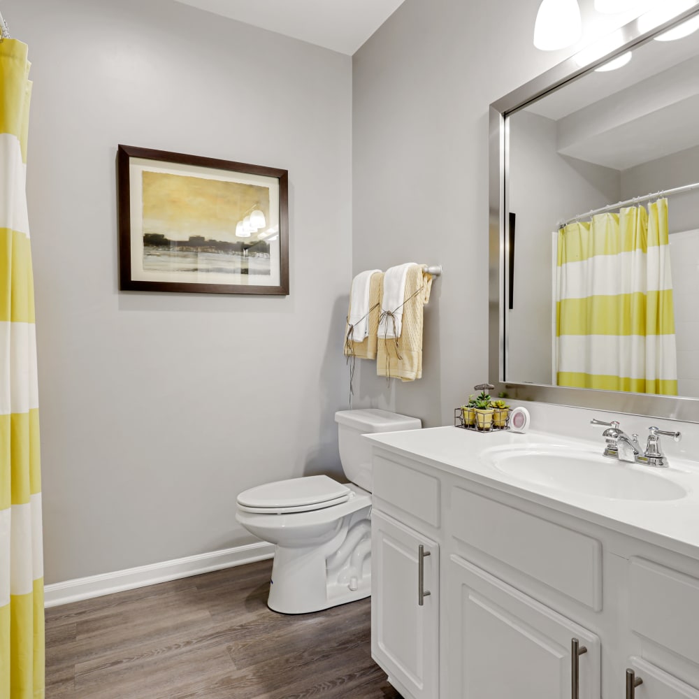 An apartment bathroom with attached closet at The Courts of Avalon in Pikesville, Maryland