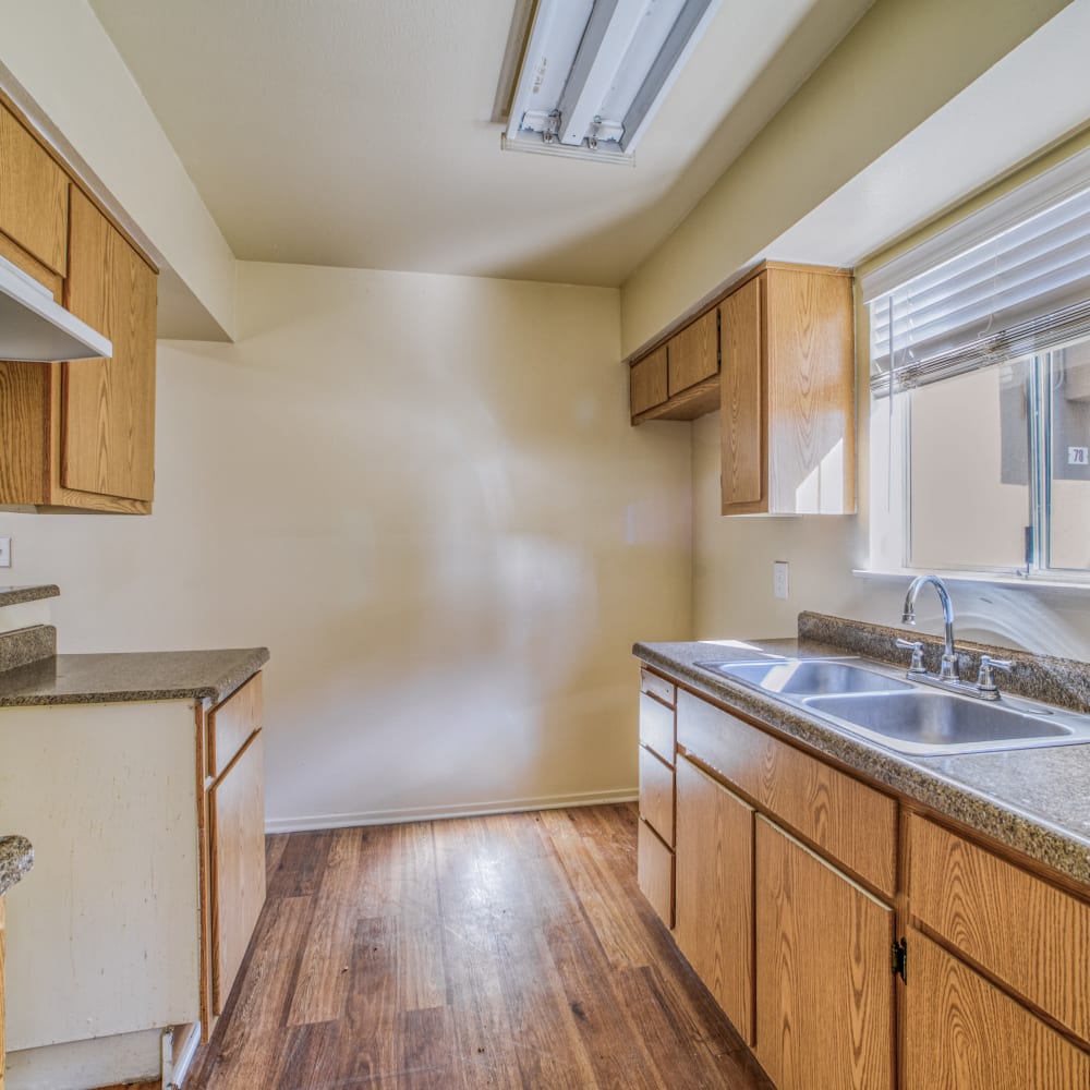 Apartment kitchen featuring eco-friendly flooring and new fixtures at Kings Villages in Pasadena, California