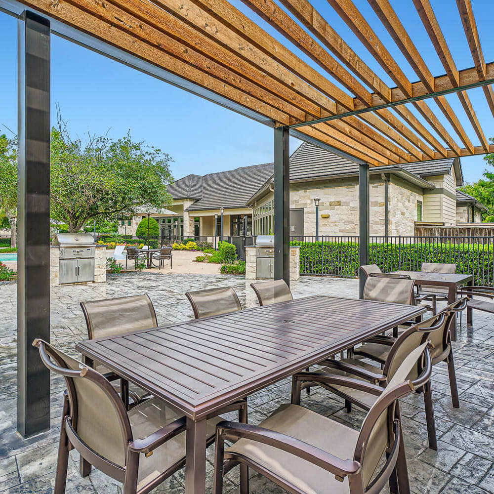 Poolside table and chairs with covered shade area at Discovery at Kingwood in Kingwood, Texas