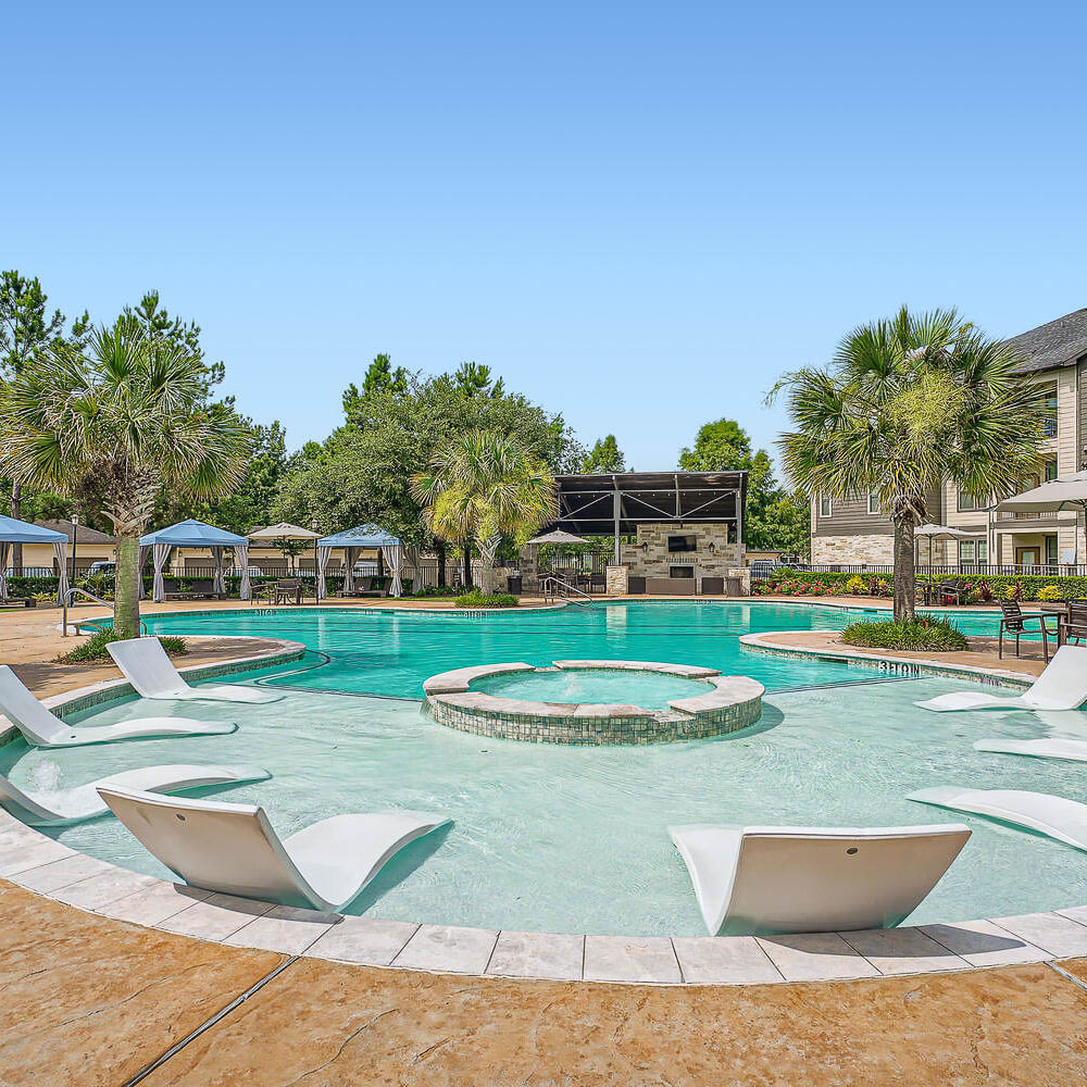 Lounge chairs in shallow pool lounge and hot tub at Discovery at Kingwood in Kingwood, Texas