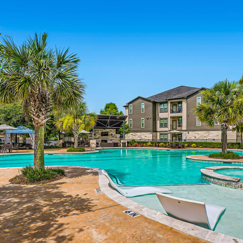 Poolside view with mature palm trees at Discovery at Kingwood in Kingwood, Texas