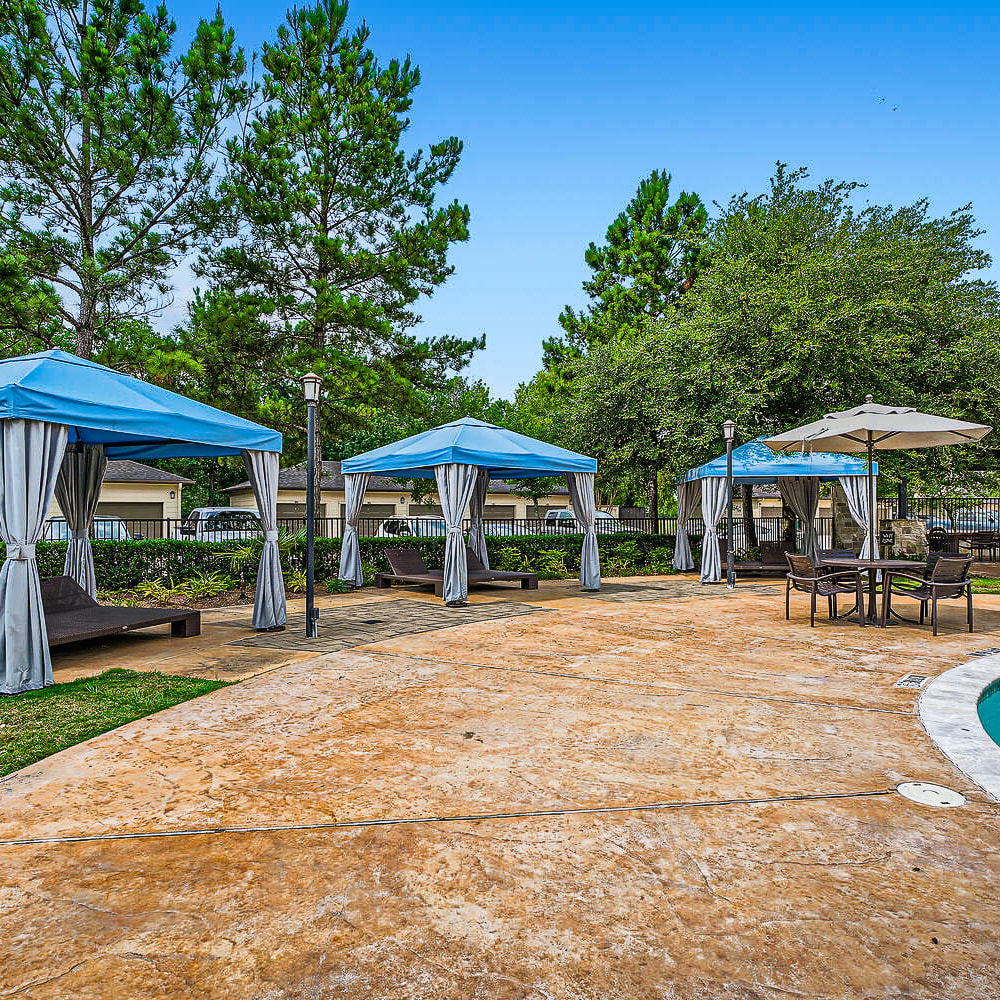 Poolside cabanas and chairs with privacy screens at Discovery at Kingwood in Kingwood, Texas