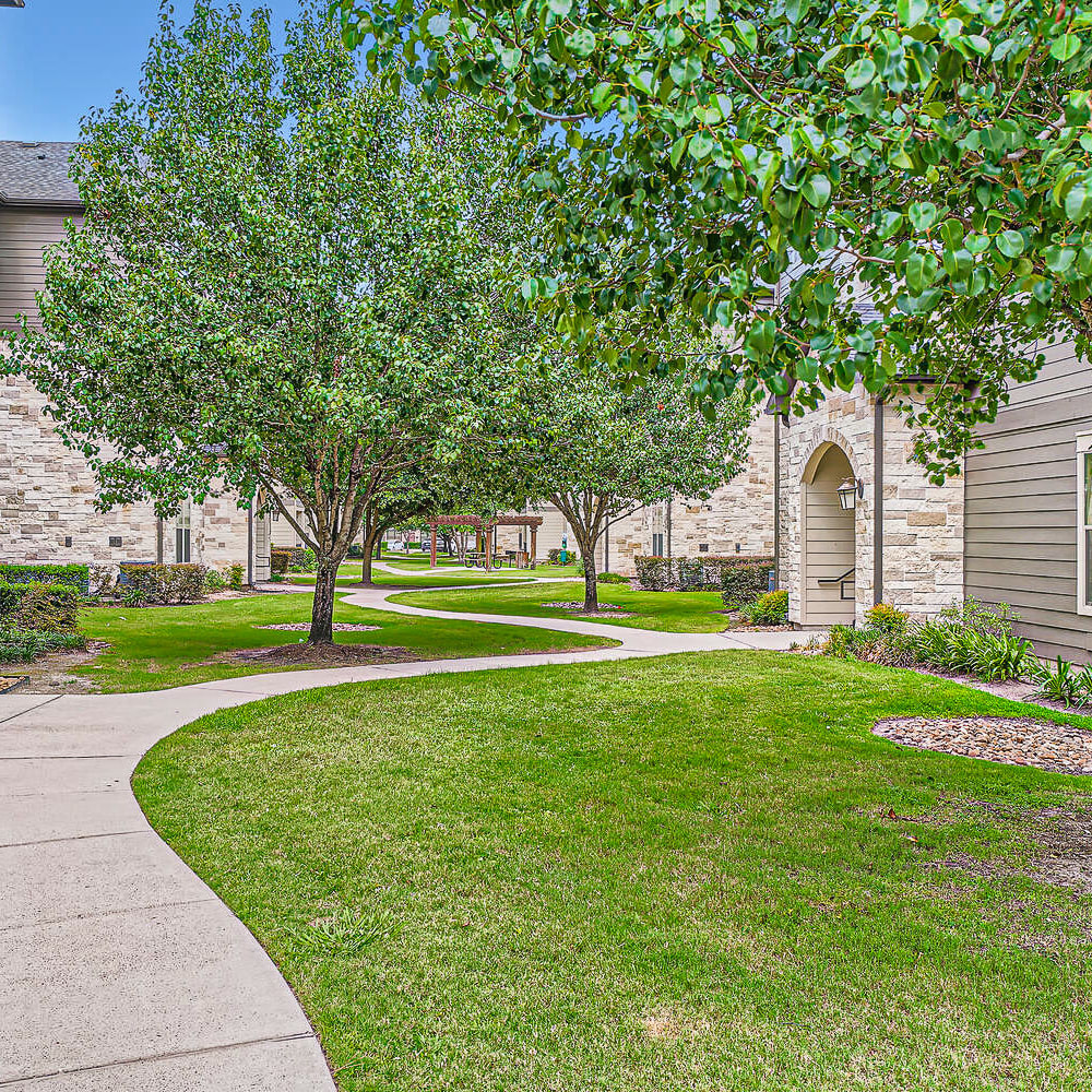 Garden style community with walk paths and mature trees at Discovery at Kingwood in Kingwood, Texas
