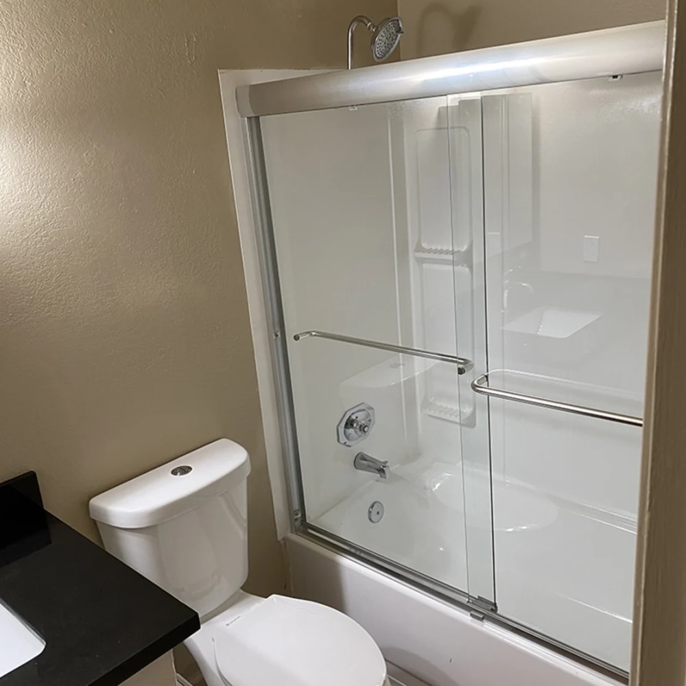 Bathroom with sliding glass door shower enclosure at Iron Horse Apartments in Stockton, California