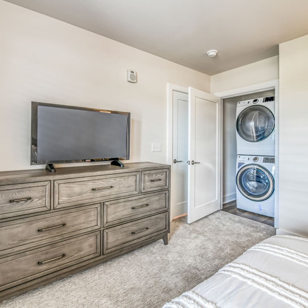 Bedroom adjacent to a small room with a laundry machine at The Regency, McKees Rocks, Pennsylvania