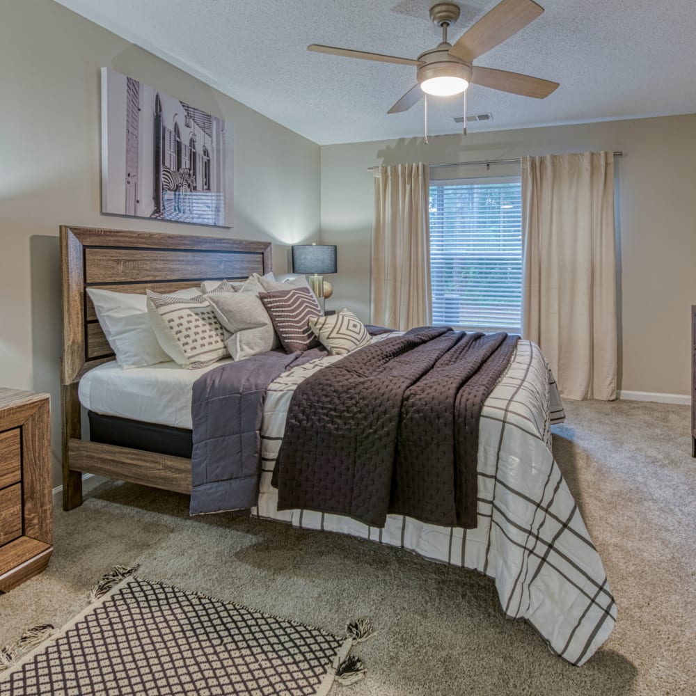 A furnished bedroom with a ceiling fan at The Glen at Lanier Crossing in Stockbridge, Georgia