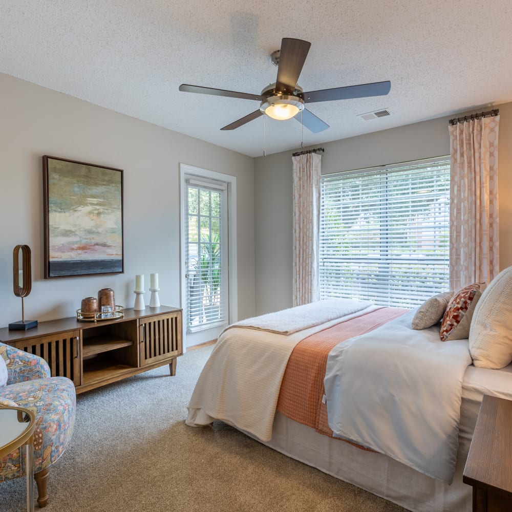 A furnished apartment bedroom with a large window at Granby Crossing in Cayce, South Carolina