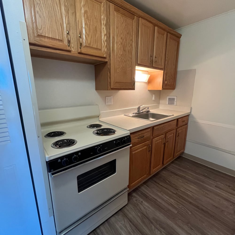 Fully equipped kitchen with natural wood cabinets at Perrytown Place in Pittsburgh, Pennsylvania