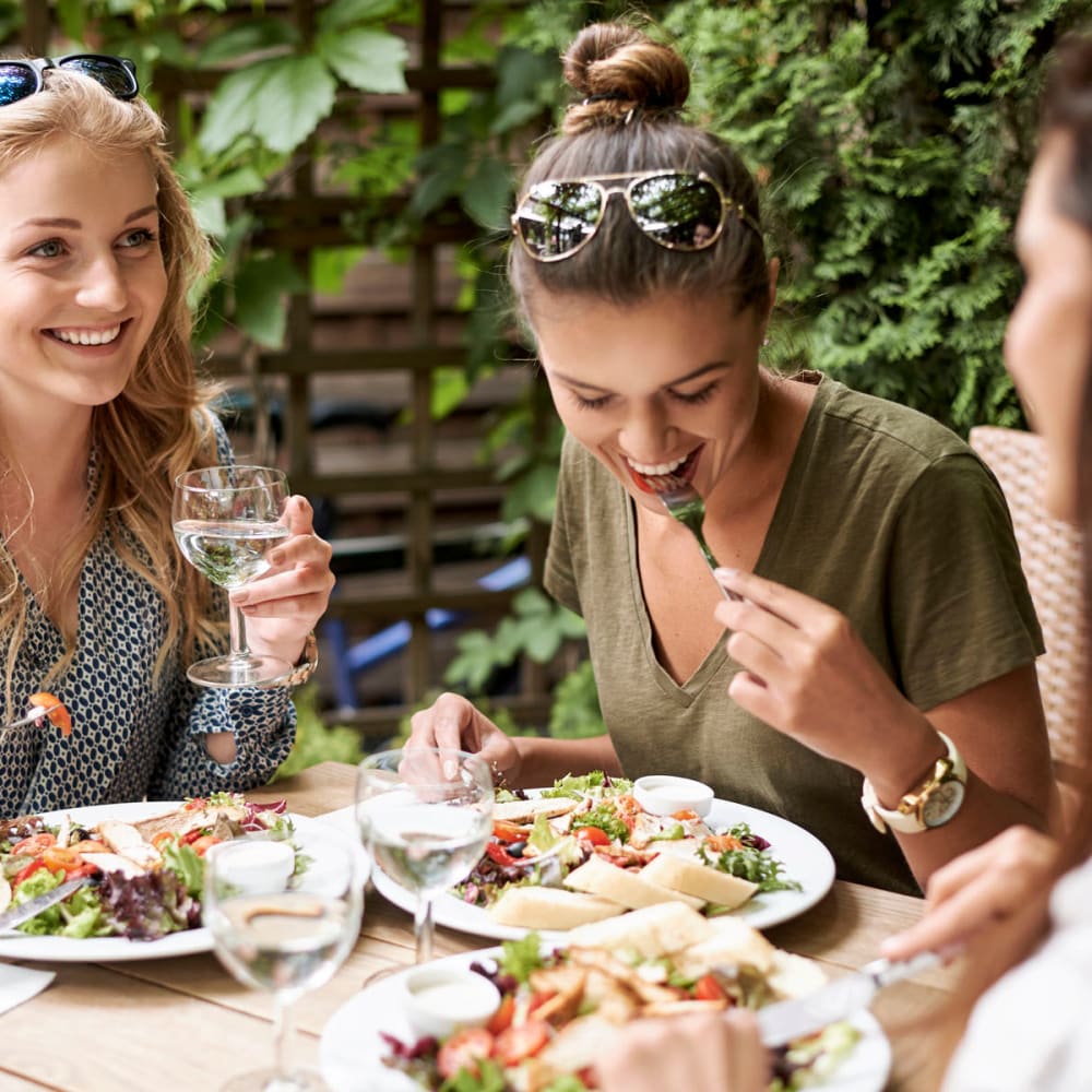 Happy friends enjoying dinner near La Pro Apartments in Los Angeles, California