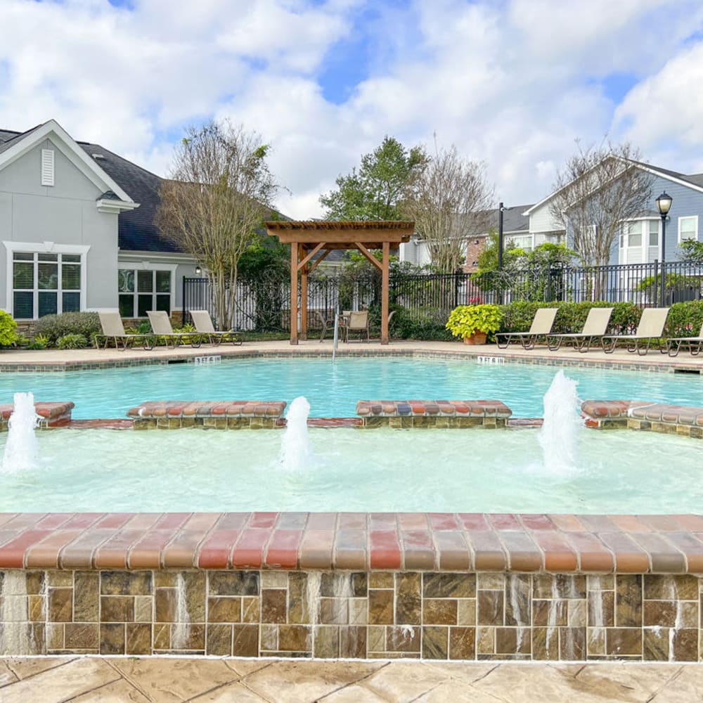 Community resort-style pool with water features at Villas at West Road in Houston, Texas