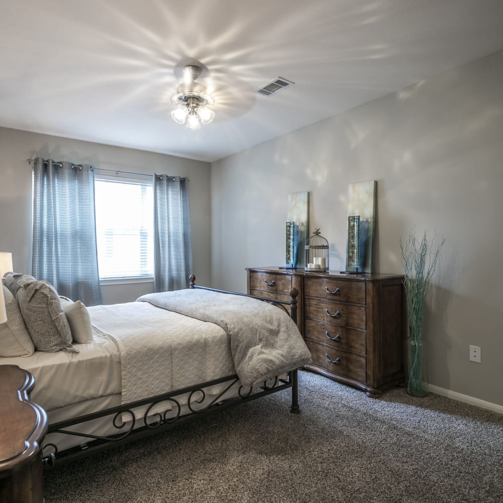 Model bedroom with large windows at Villas at West Road in Houston, Texas