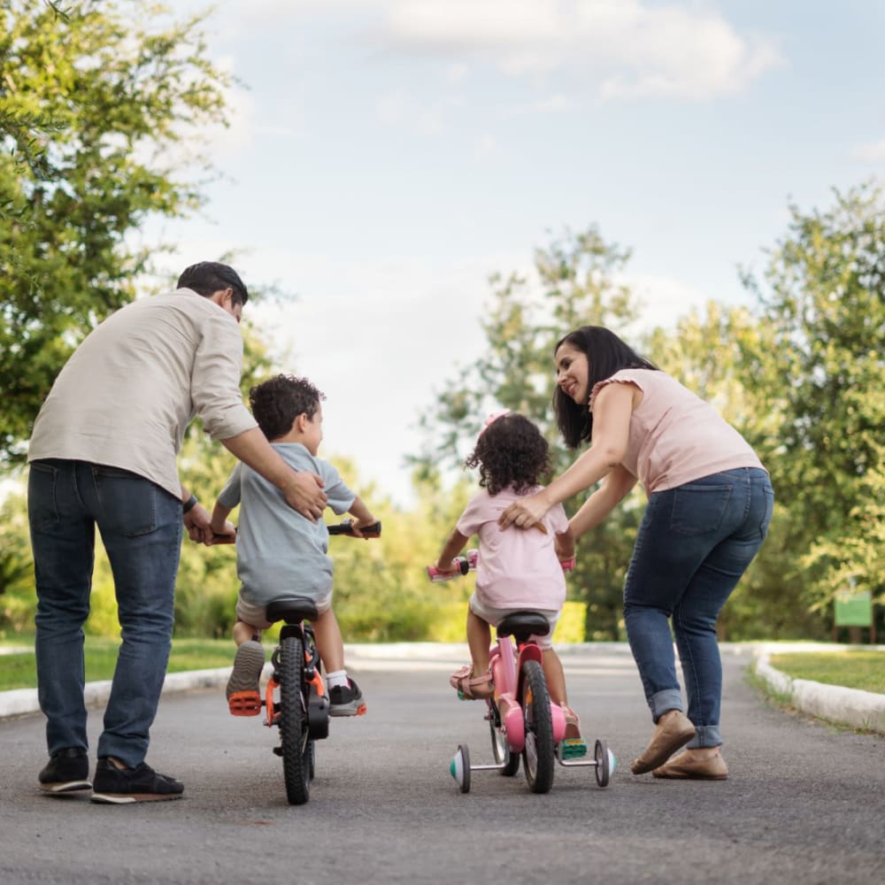 Family riding bikes near Courtyard Apartments in Stockton, California