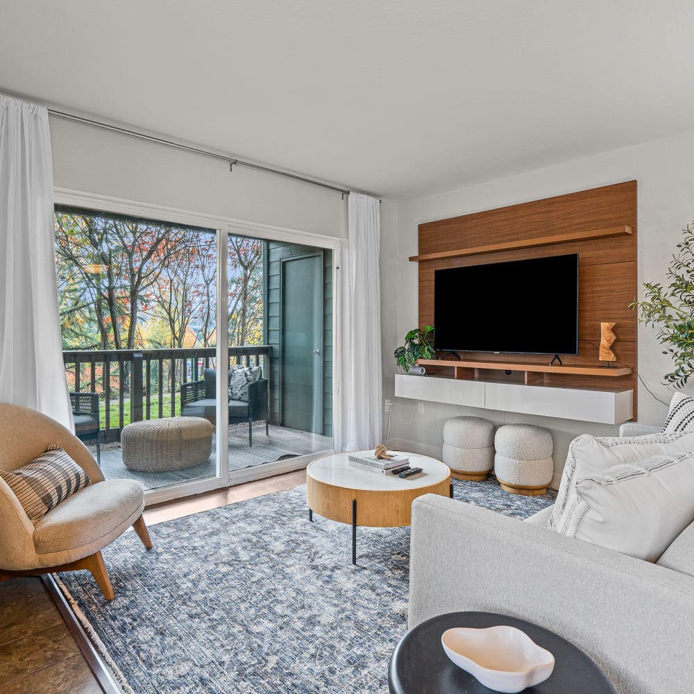 Open-concept living areas with a private balcony and hardwood style flooring at Timbers at Tualatin in Tualatin, Oregon