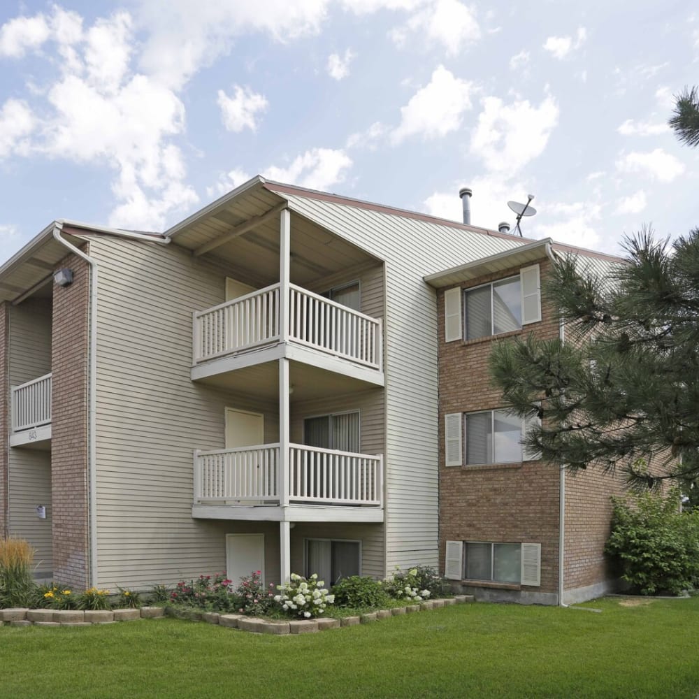 Exterior of an apartment building and patios at Chadds Ford Apartments in Midvale, Utah