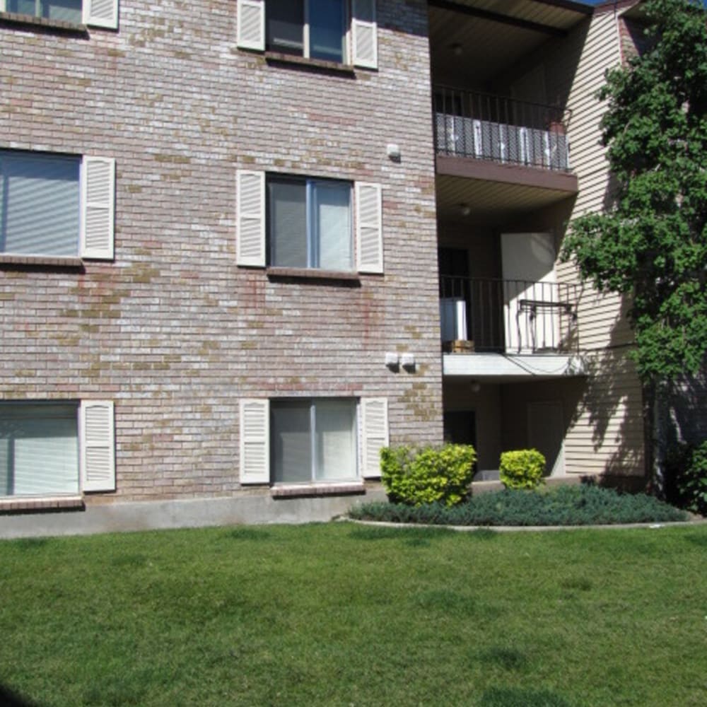 A manicured lawn in front of an apartment building at Falcon Park Apartments in Layton, Utah