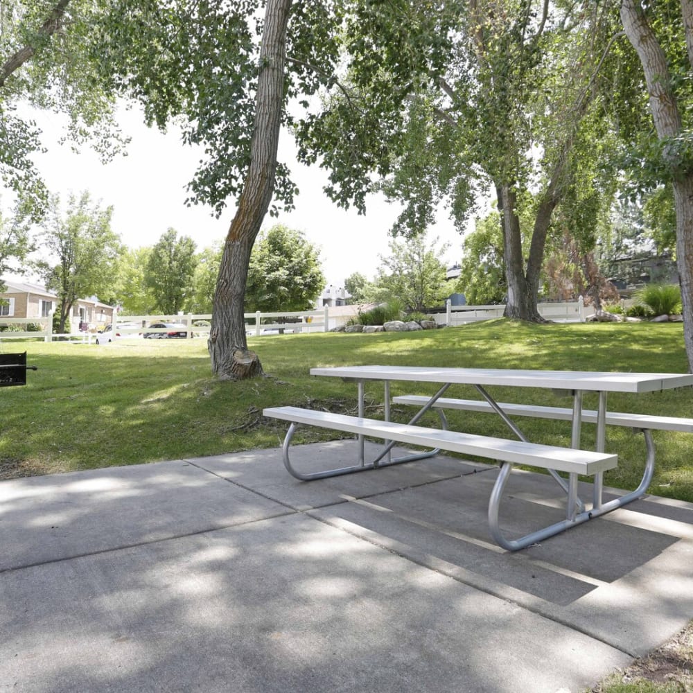 An outdoor table in the shade of trees at Highland Pointe Apartments in Cottonwood Heights, Utah