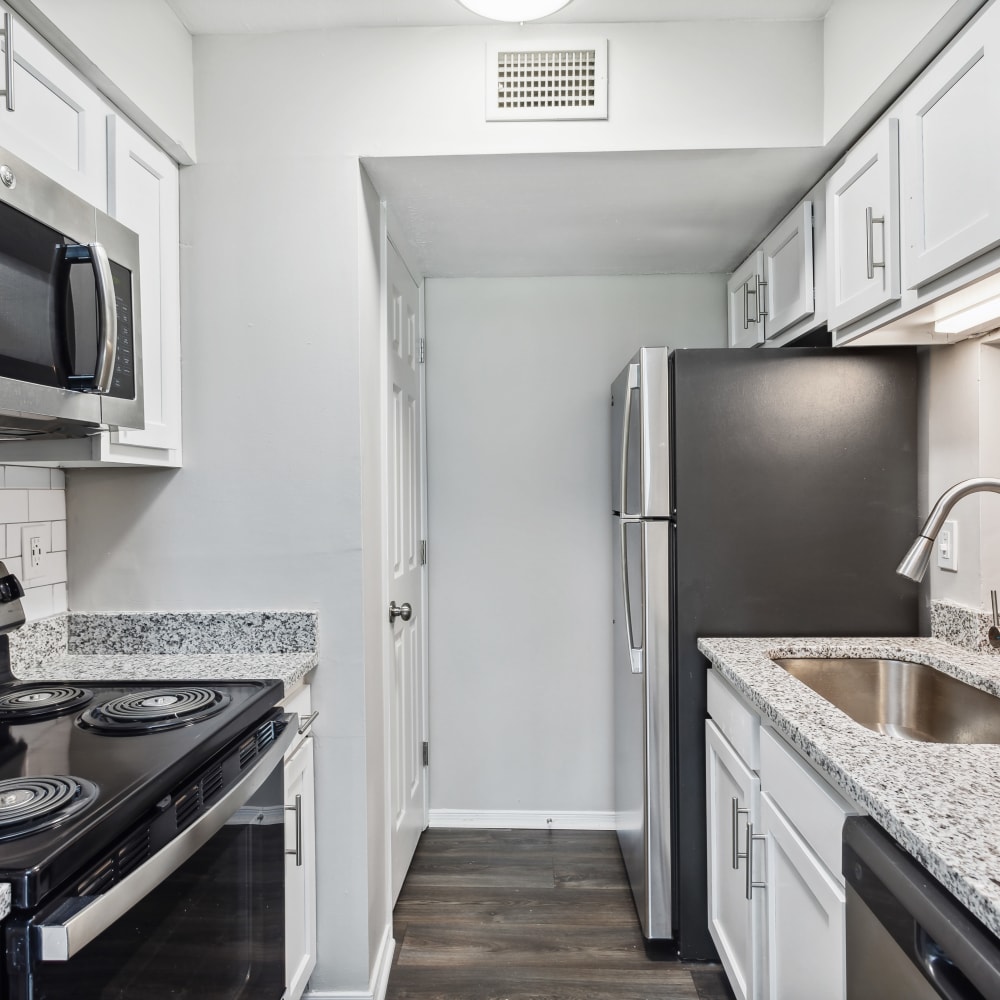 A model apartment kitchen with a backsplash at Park West End in Richmond, Virginia