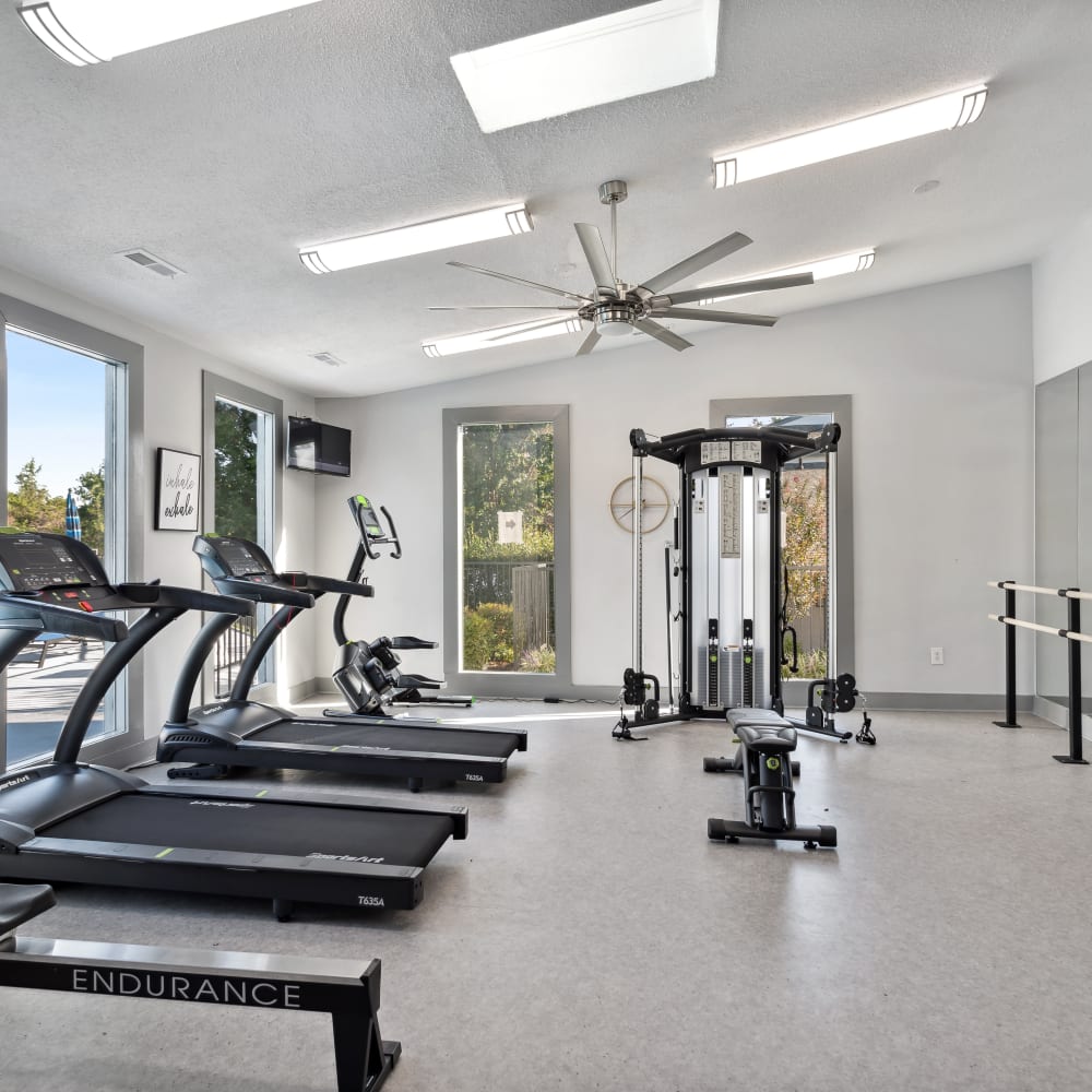 A row of treadmills facing a window in the fitness center at Park West End in Richmond, Virginia