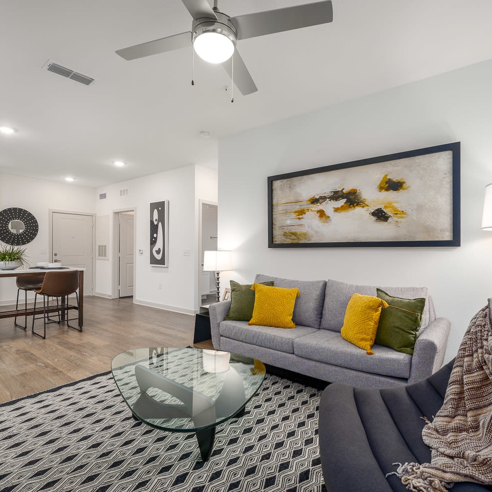 Wood flooring and a ceiling fan in a furnished apartment living room at Novo Westlake in Jacksonville, Florida