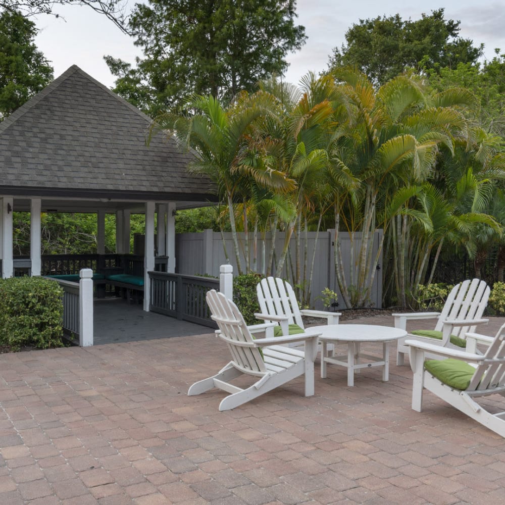 Outside table and chairs by the pool at Lakeview at Palm Harbor in Palm Harbor, Florida