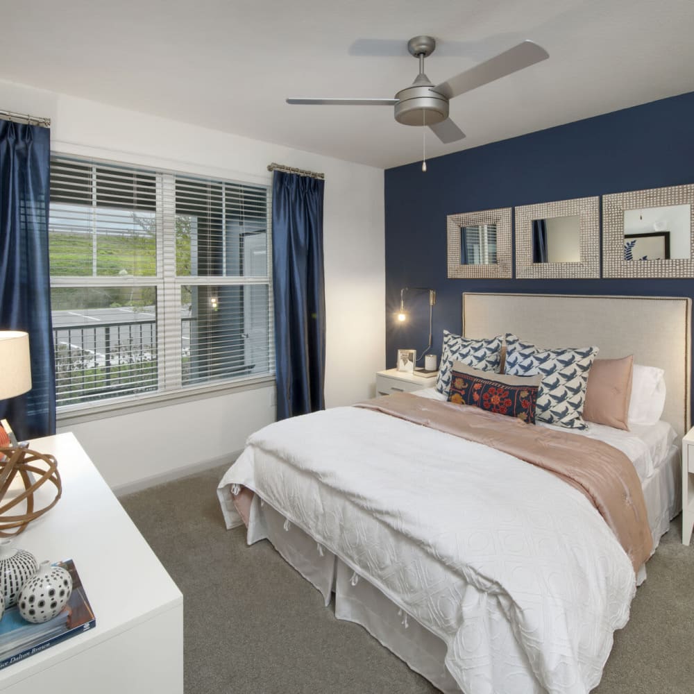 Master bedroom with a ceiling fan at Alcove Apartments in Orlando, Florida