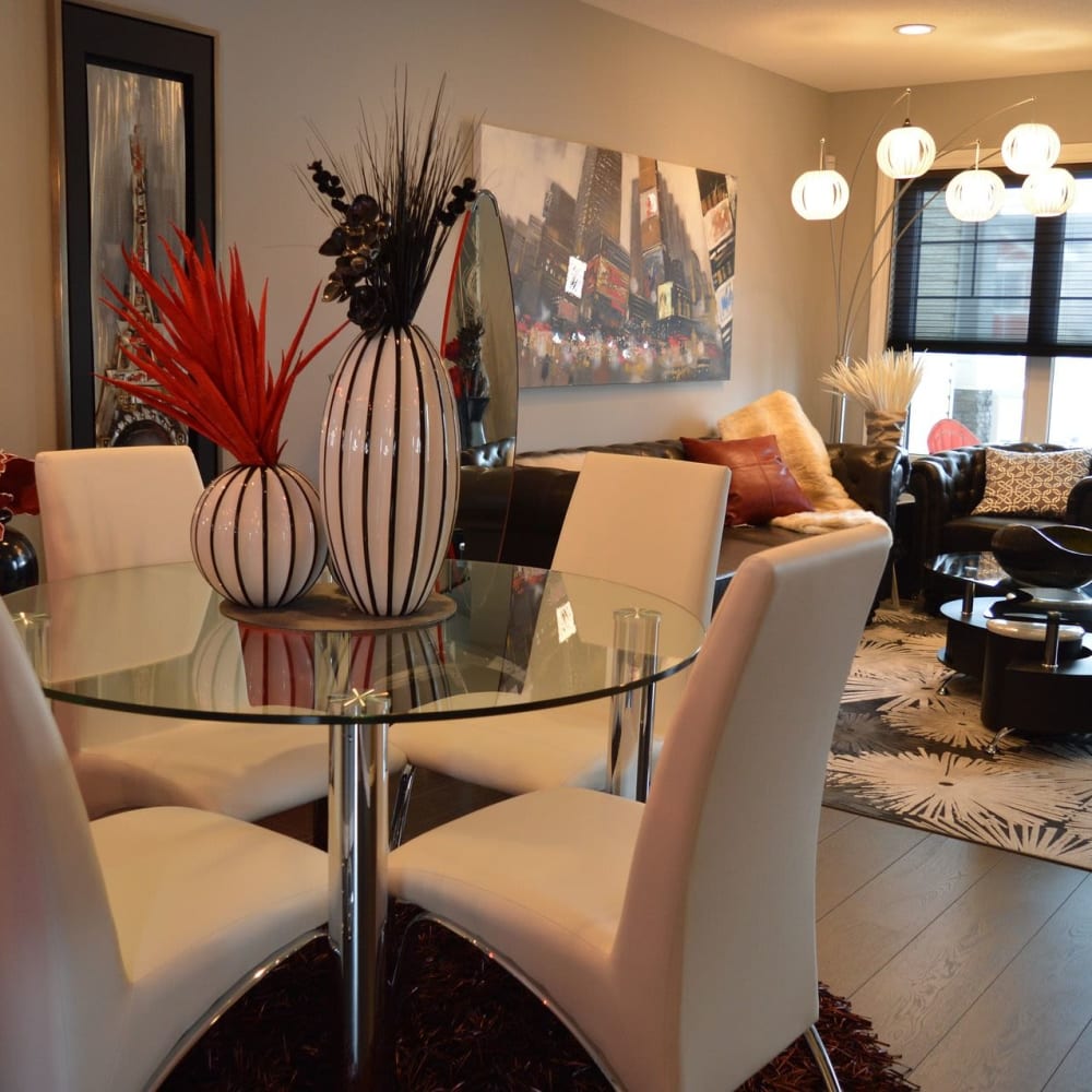 A glass dining table and chairs in a furnished apartment dining room at Clinton Towne Center Apartments in Clinton, Utah