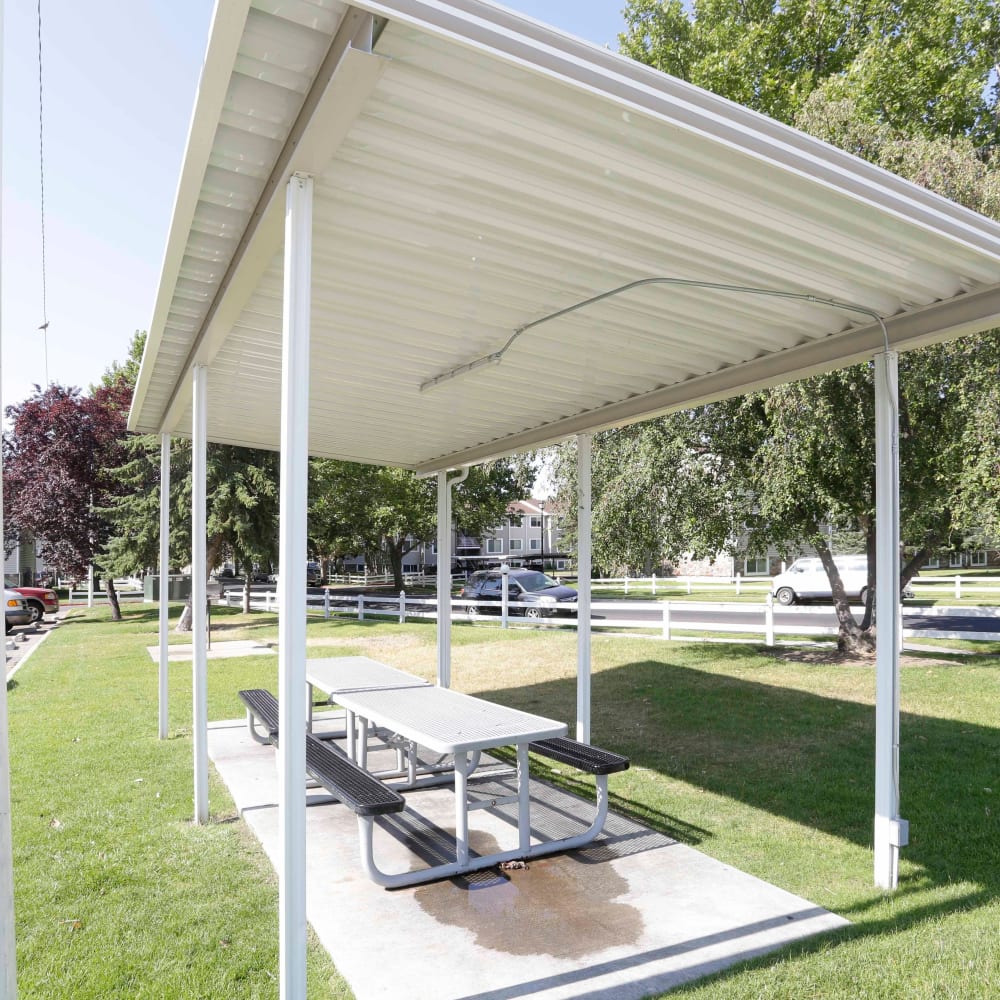 A covered outdoor area with picnic benches at Mark Twain Apartments in Salt Lake City, Utah