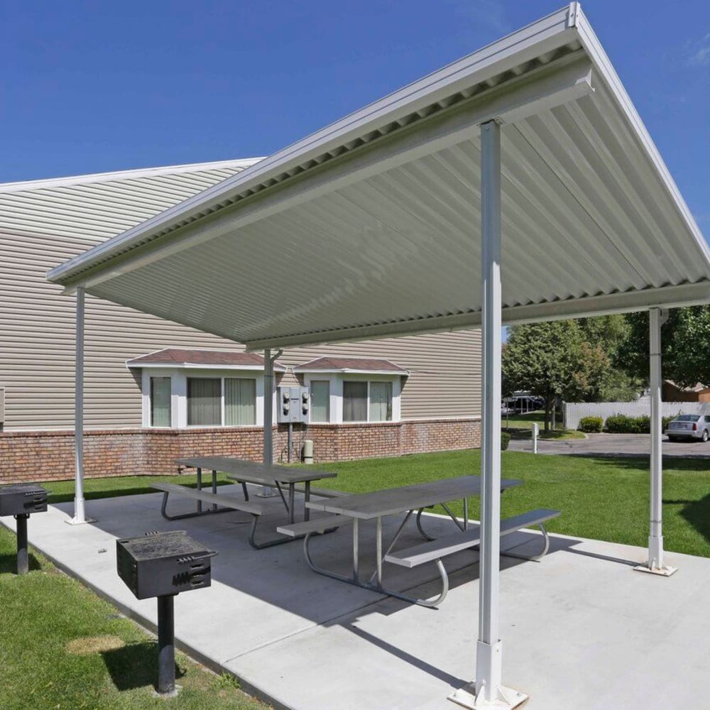 Shaded outdoor tables and grills at Valley Park Apartments in Salt Lake City, Utah