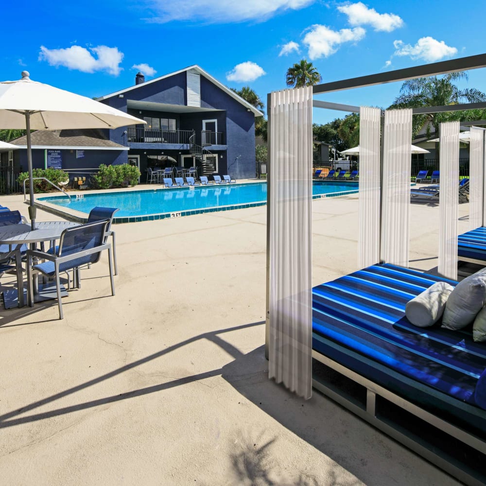 Pool side relaxation with lounge chairs and umbrellas at WestEnd Apartments in Tampa, Florida