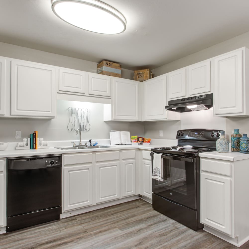 Wood flooring and white cabinets in an apartment kitchen at Spring Lake in Byram, Mississippi