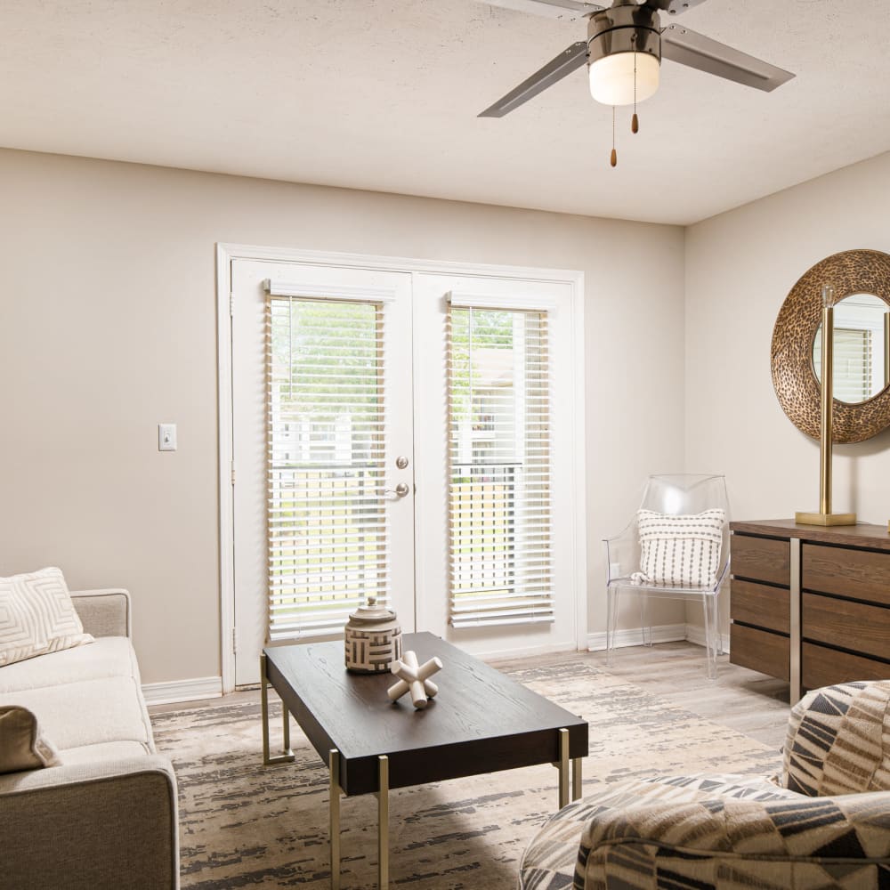 An apartment living room with a ceiling fan and doors to the balcony at Midsouth 301 in Jackson, Mississippi