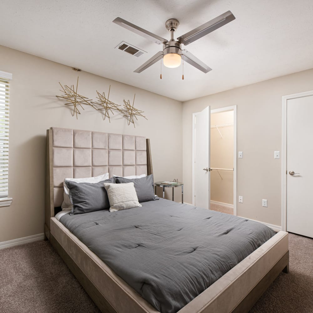 A king sized bed and ceiling fan in an apartment at Midsouth 301 in Jackson, Mississippi