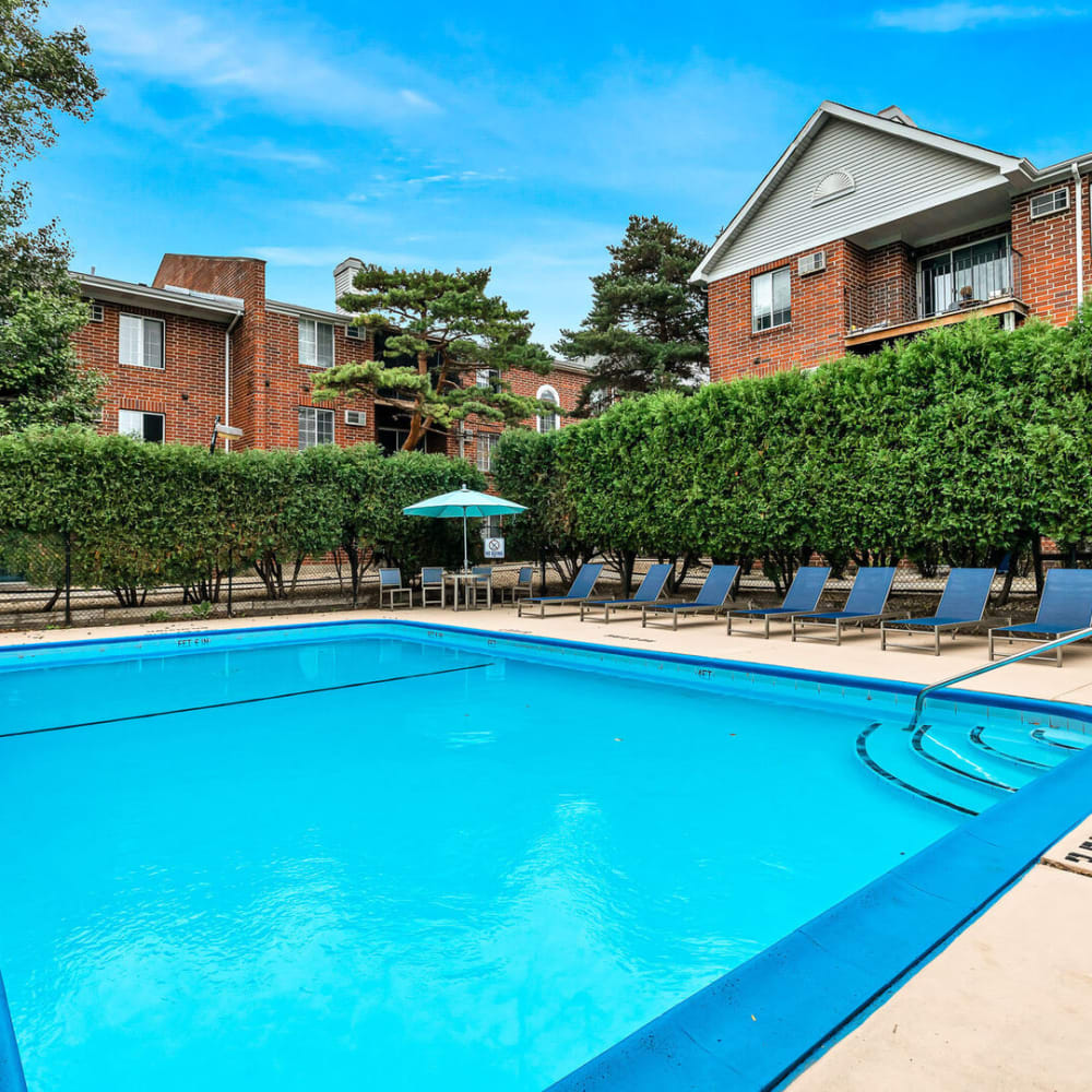 Outdoor seating surrounding the community swimming pool at Huntington Apartments in Naperville, Illinois