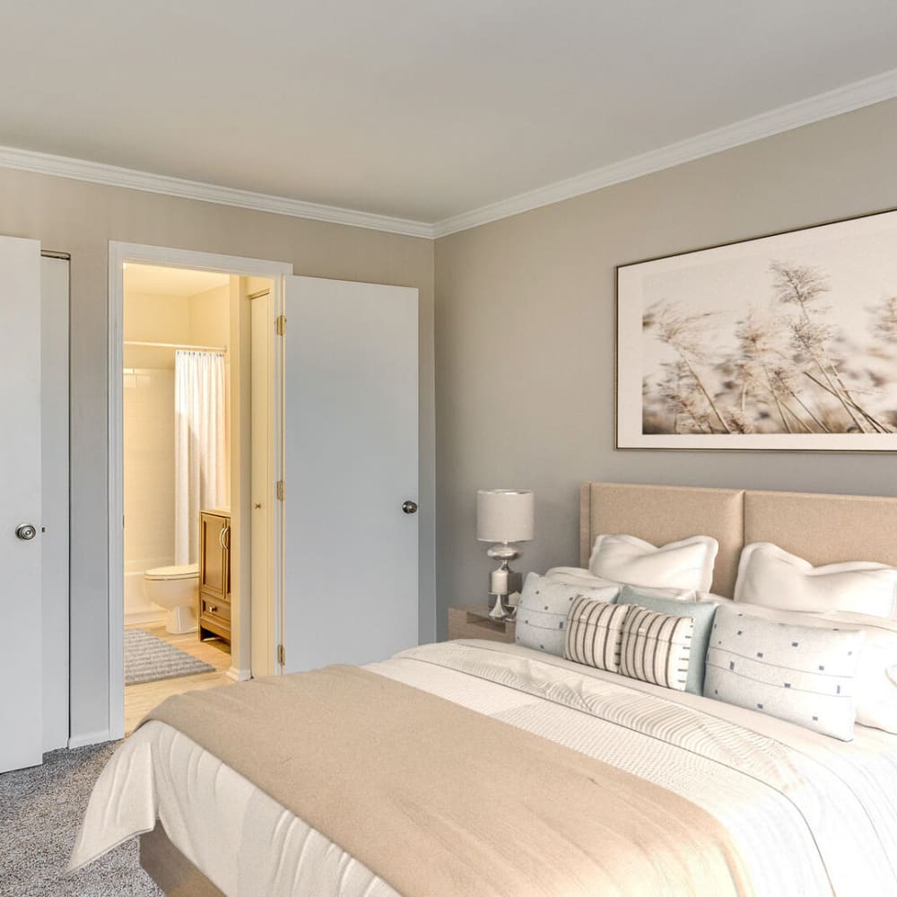 A furnished bedroom with an attached bathroom at Huntington Apartments in Naperville, Illinois