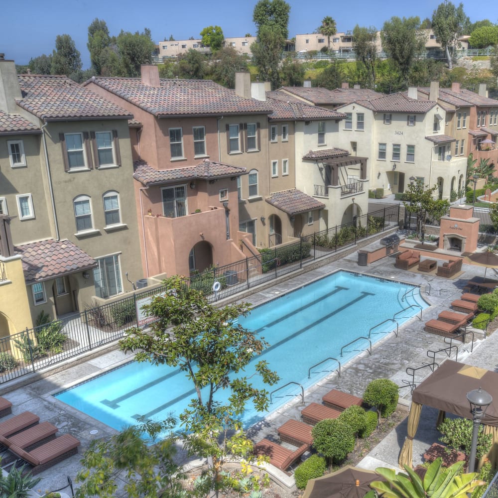 Refreshing outdoor swimming pool and apartment buildings at Piazza D'Oro in Oceanside, California